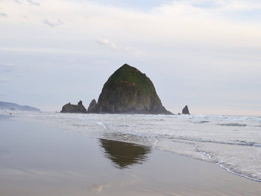 Empty sandy ocean beach and Haystack Rock in Cannon Beach