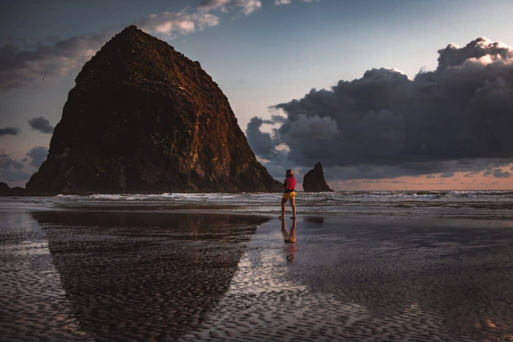 Person Walking on Seashore at Haystack Rock in Cannon Beach