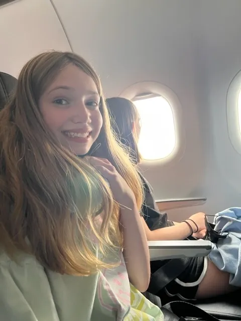 Girl with a neck pillow on an airplane