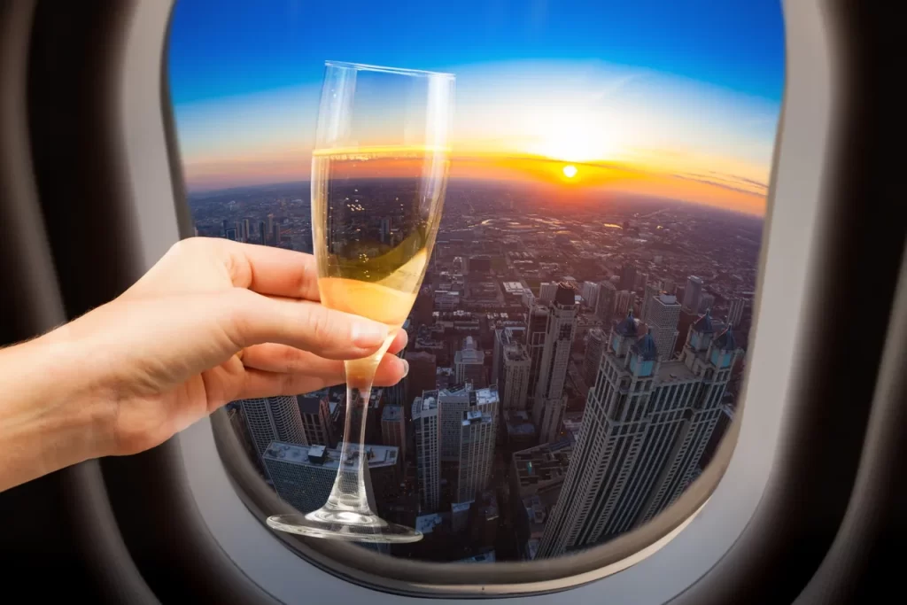 Champaign glass against the window of an airplane