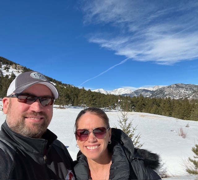 Couple smiling in the snow in Estes Park, Colorado