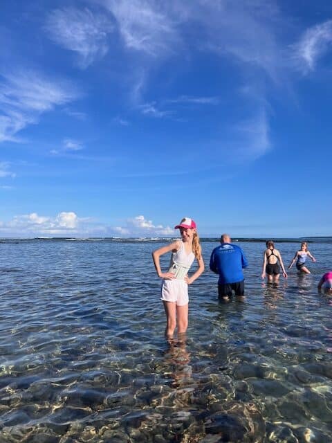 Girl wearing a hat in the beach. Hats are a good idea to pack for Hawaii. 