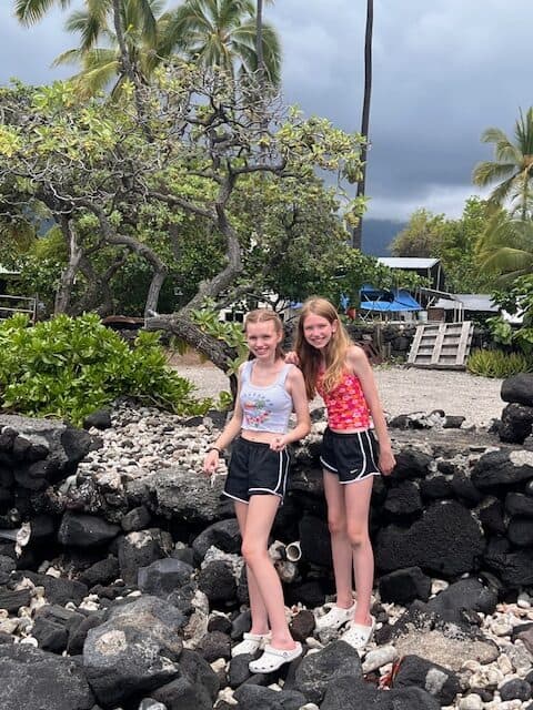 Girls on the lava rocks in the Big Island of Hawaii. They are wearing crocs which are a great item to pack for the Big Island of Hawaii.
