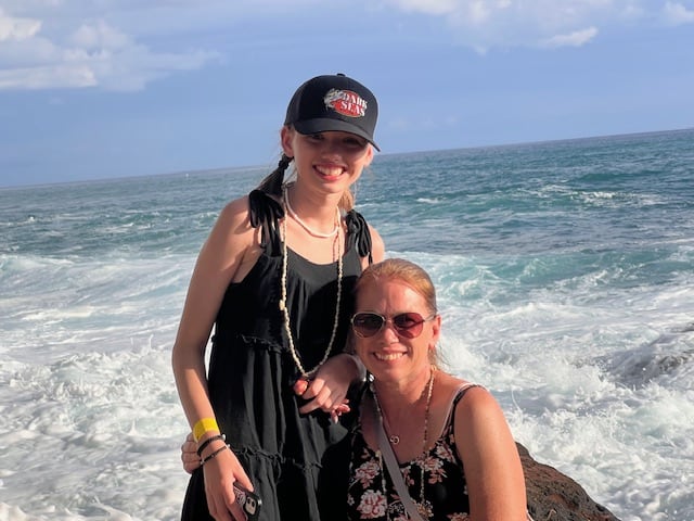 Mom and daughter in front of the ocean in Hawaii. 