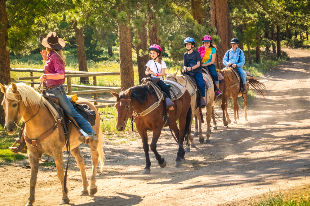 Tour guide and kids horseback riding in Colorado