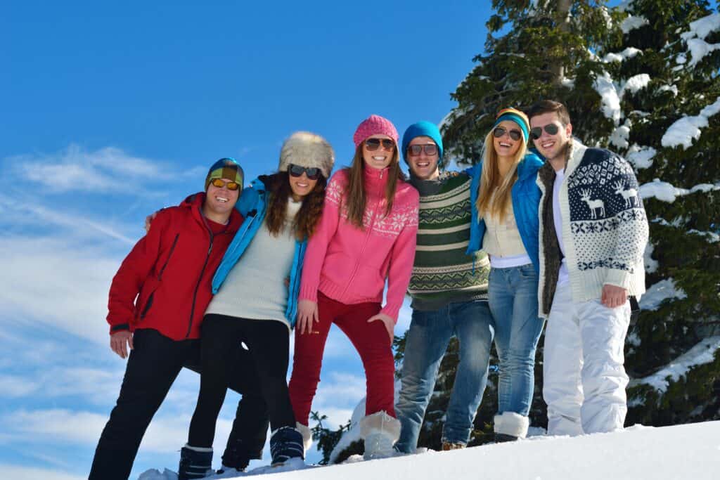 Group of friends in the snow on a sunny day in the mountains