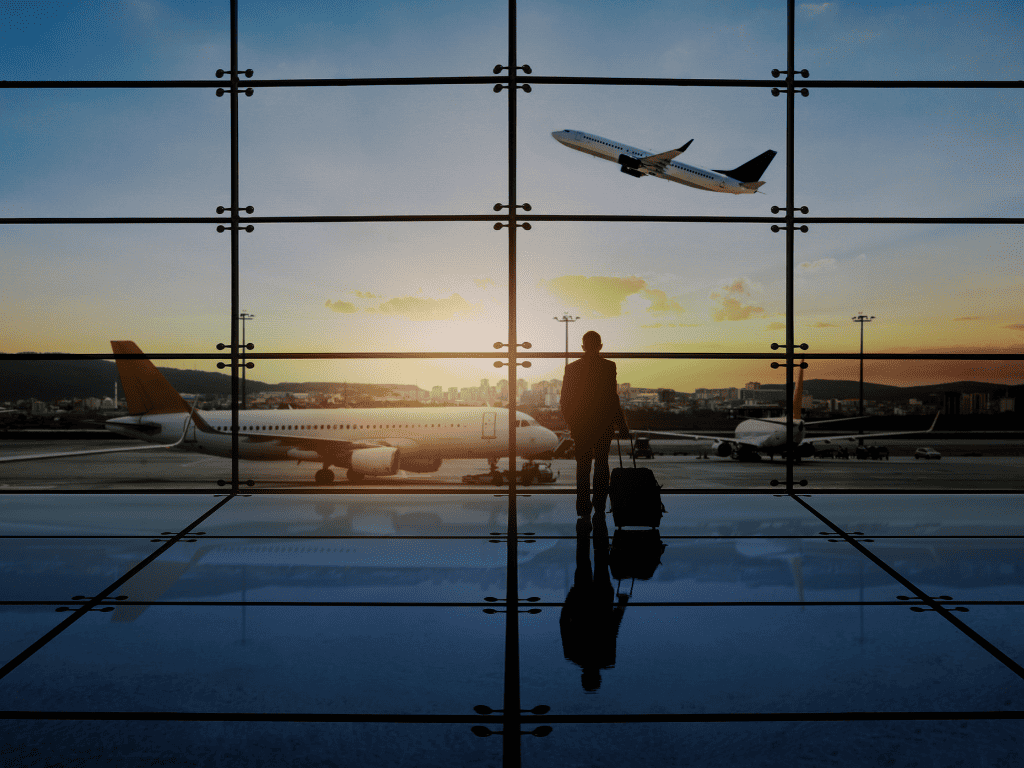 Man looking out at airplanes in an airport