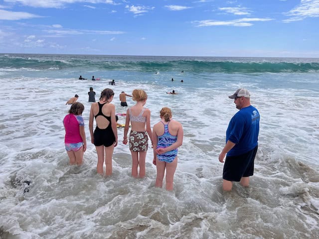 Kids playing in the waves at Magic Sands Beach in Kona, Hawaii