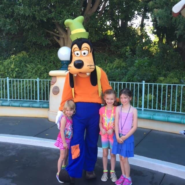 Kids posing with Goofy at Disneyland