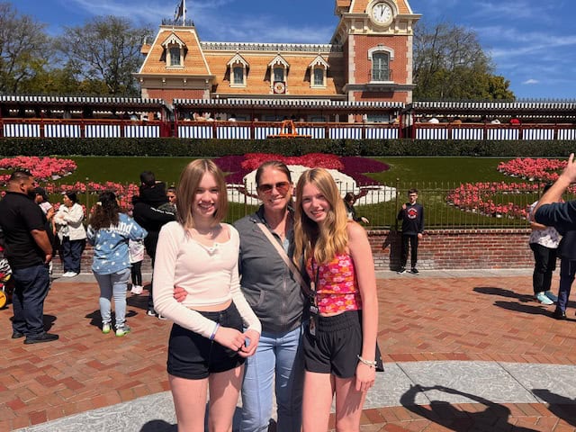 Posing with my girls at the entrance to Disneyland
