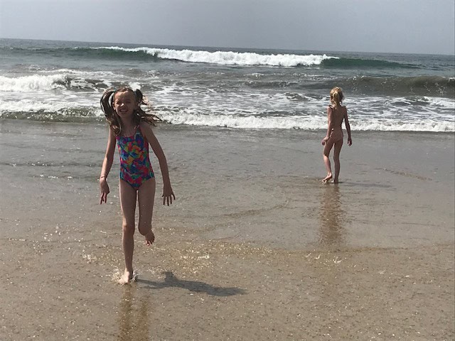 Girls playing in the waves at Huntington Beach, California