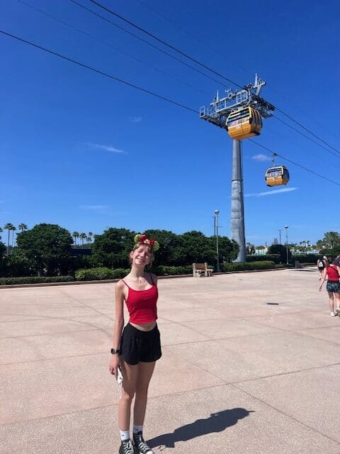 Girl standing under the Disney Skyliner gondola