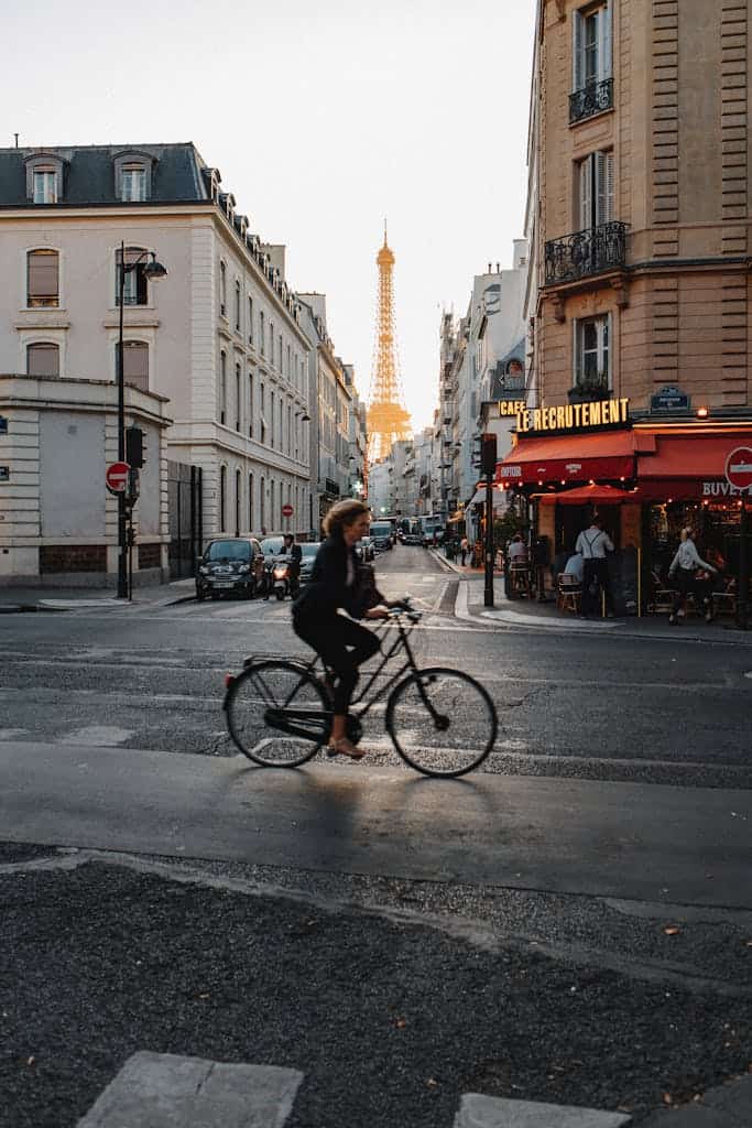 A woman riding a bicycle with the Eiffel tower in the background