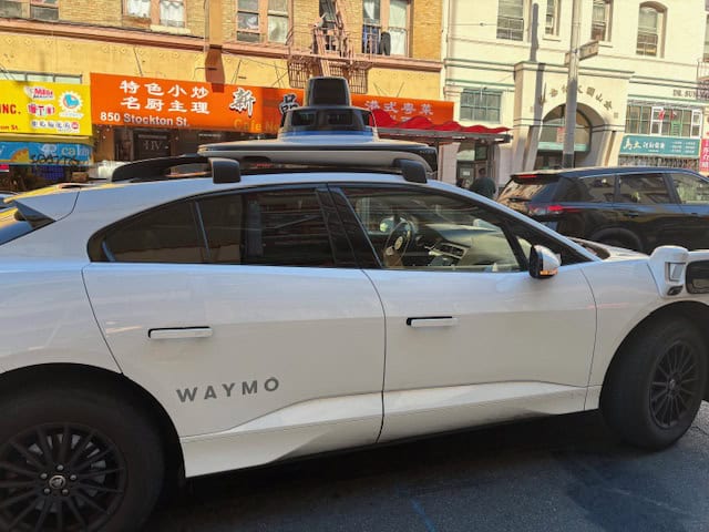 Outside view of the white Waymo driverless car.